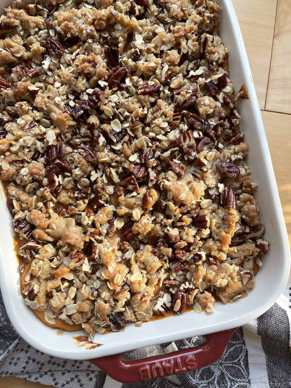 A pan of sweet potato casserole with pecan praline topping.