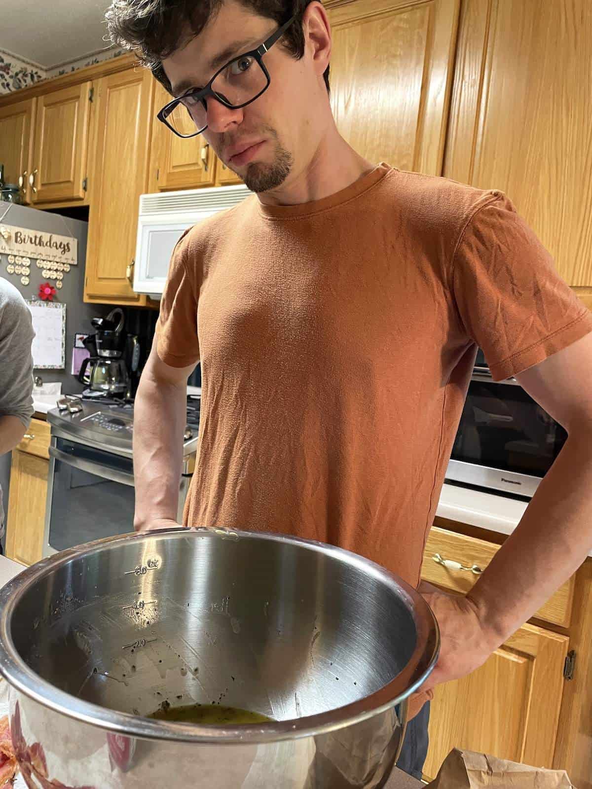 A man with glasses in a kitchen, glaring at the camera.