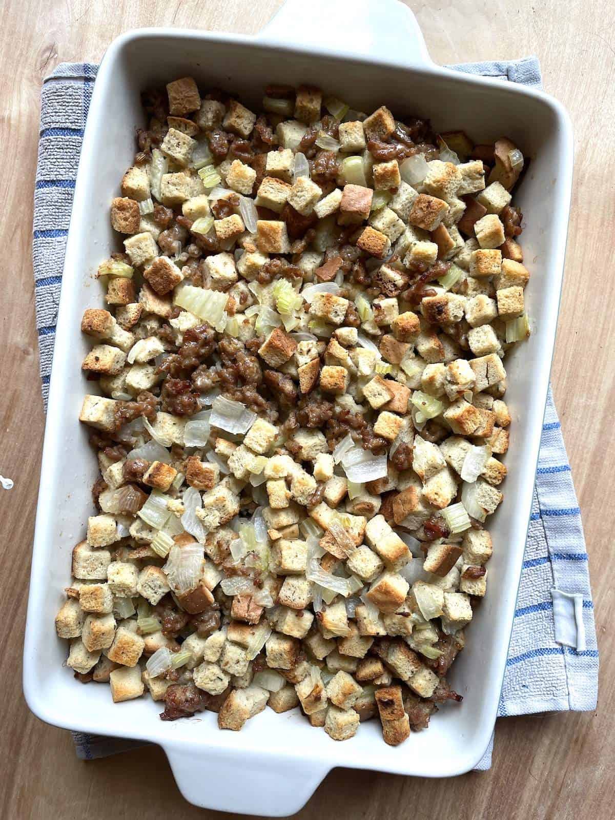 A white baking dish filled with homemade stuffing.