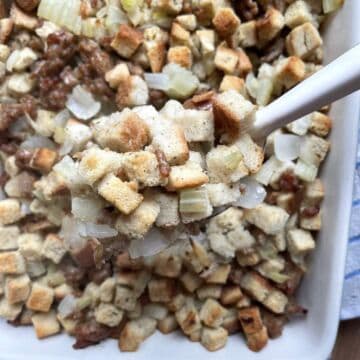 A white pan of quick and easy stuffing with a scoop of it being served.