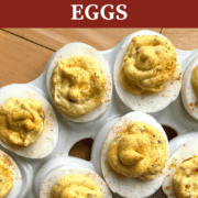 A pin image of rows of cajun deviled eggs on a white platter.