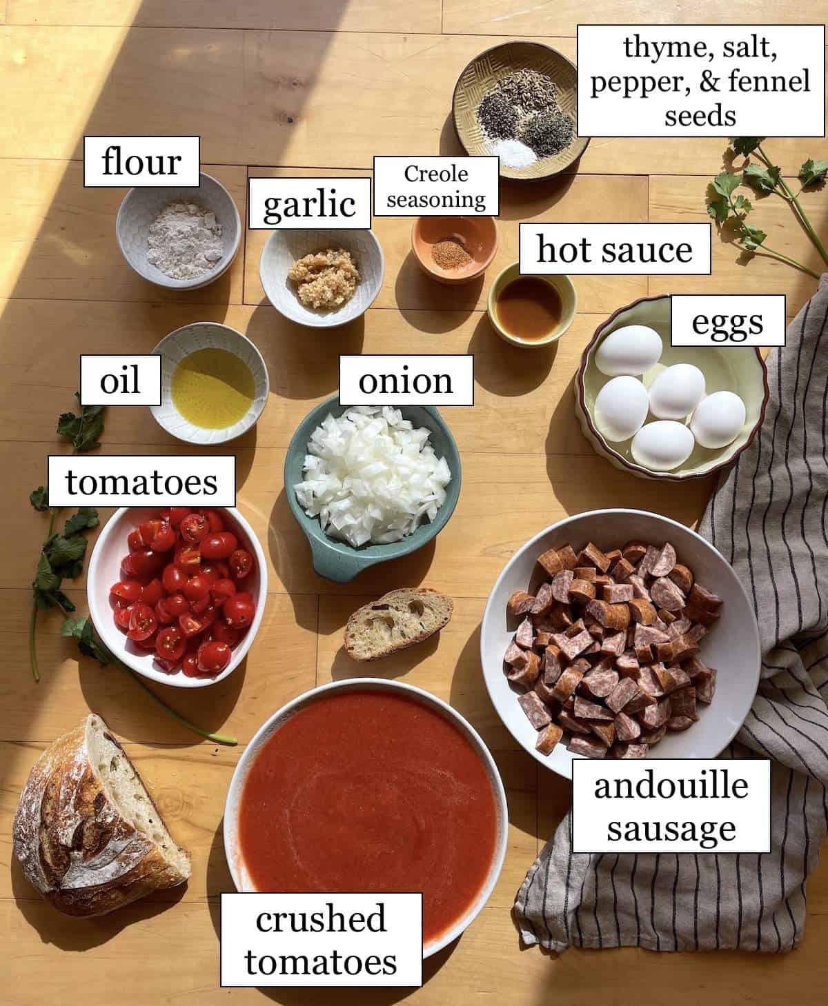 The ingredients in creole tomato shakshuka, laid out and labeled.