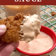 A pin image of a chicken tender dipped in boom boom sauce.