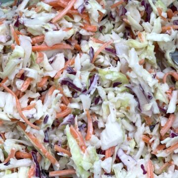 Creamy southern coleslaw (shredded carrots & cabbage covered in mayonnaise) up close.