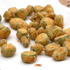 Cornmeal crusted fried okra draining on a paper towel.