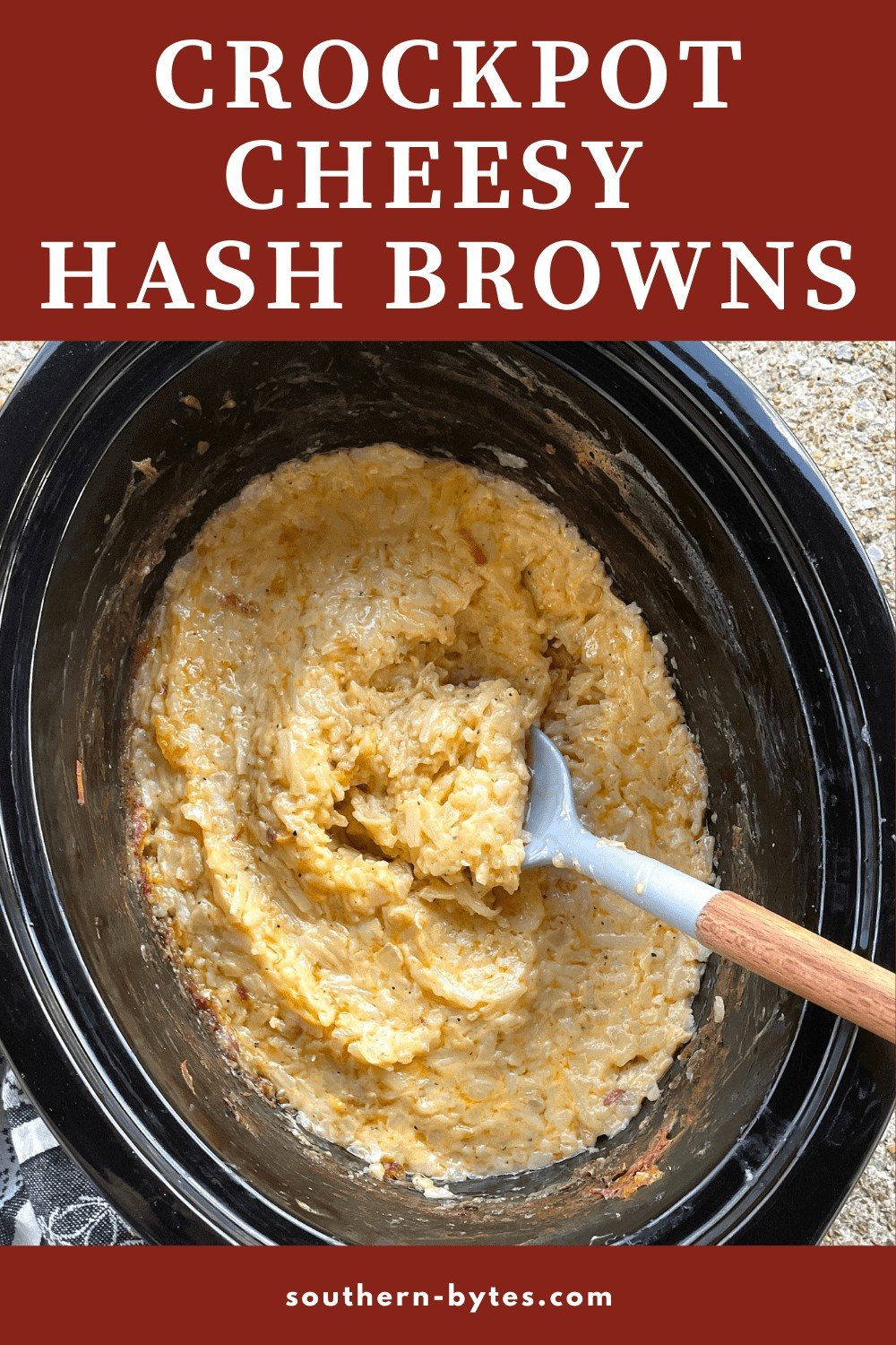 A pin image of a crockpot of cheesy hash brown potatoes.