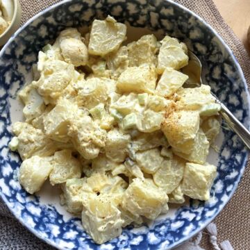 A bowl of creamy southern potato salad with a mustard based dressing.