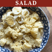 A pin image of a bowl of homemade potato salad with pickles and celery topped with hard-boiled eggs.