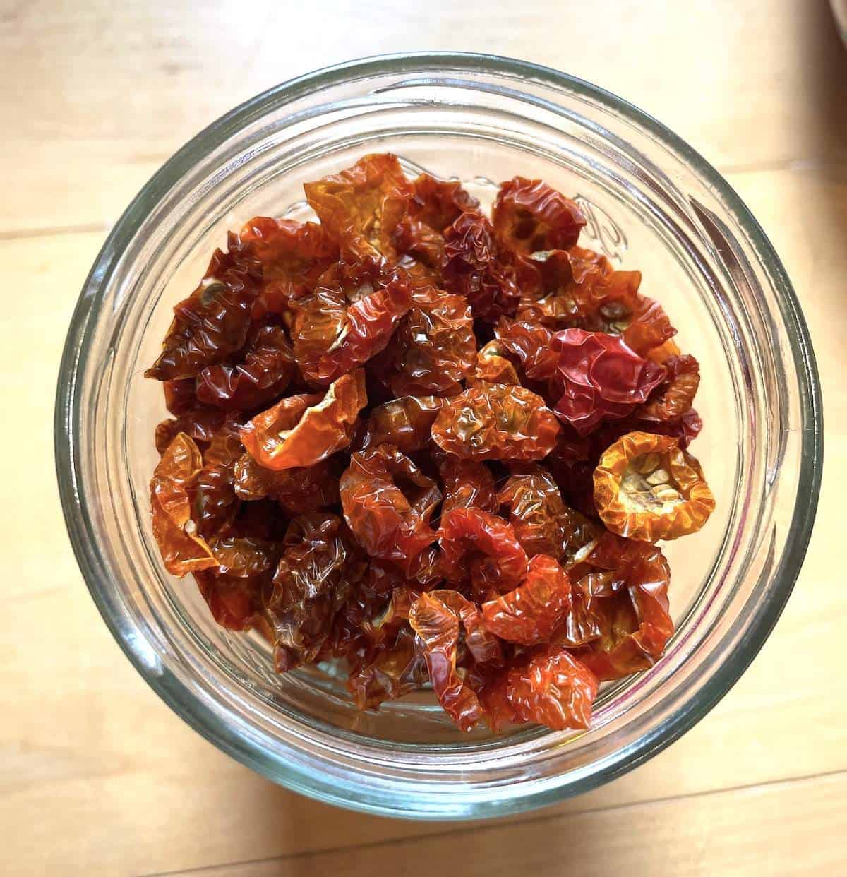 A jar filled with dehydrated cherry tomatoes.