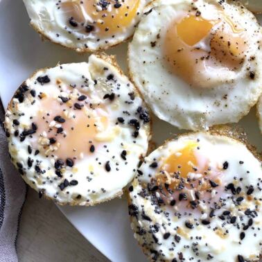 Eggs baked in a muffin tin on plate topped with everything bagel seasoning.