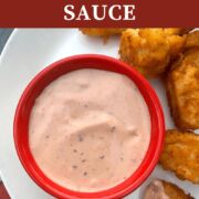 A pin image of a small red bowl of Raising Cane's Sauce with chicken tenders.