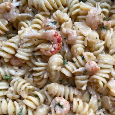 A close up image of creamy crawfish pasta and a white wine, cream, & butter sauce.