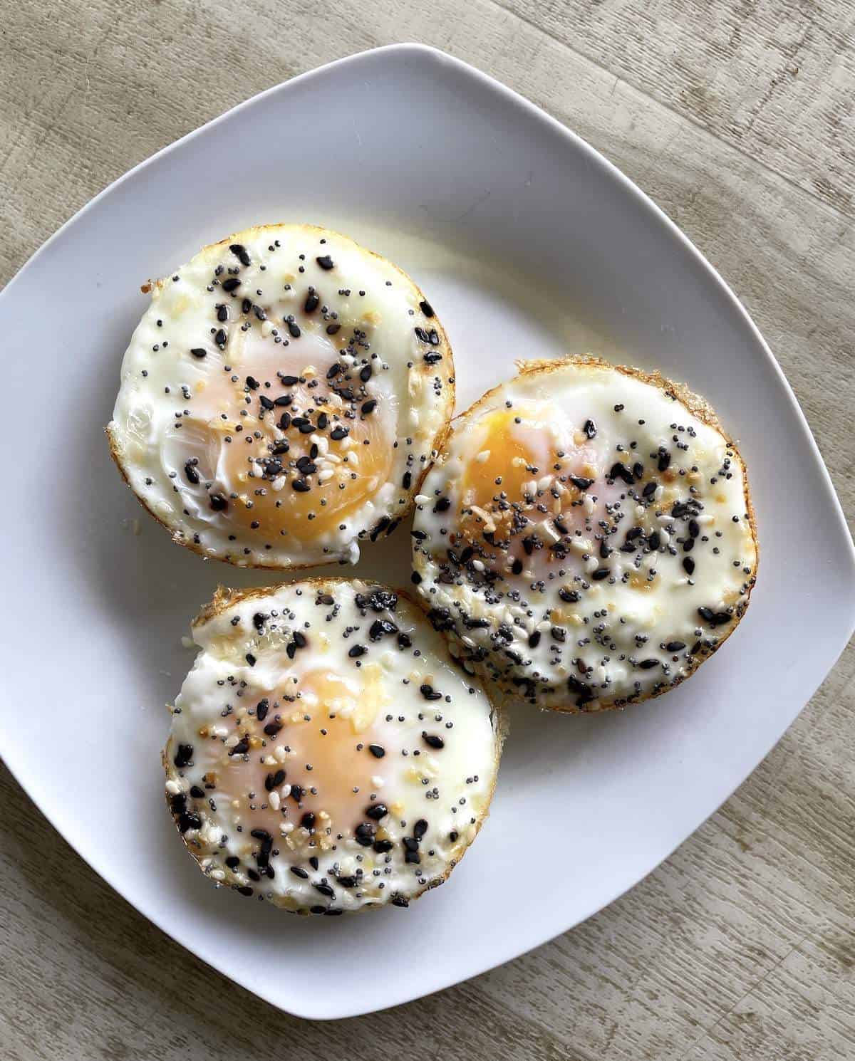 Three soft-boiled muffin tin baked eggs on a square white plate.