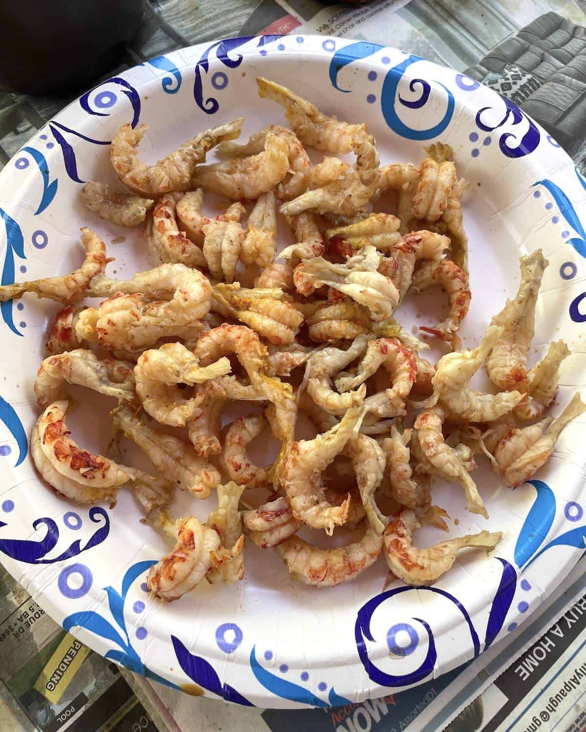 A paper plate of leftover peeled crawfish tails from a crawfish boil.
