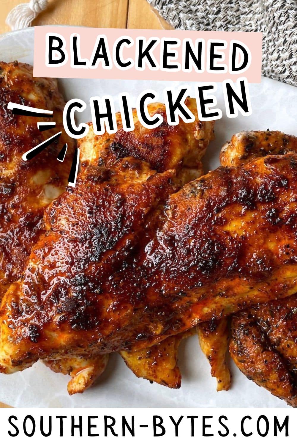 Juicy blackened chicken fillets with a crispy seasoning crust, served on a wooden surface.