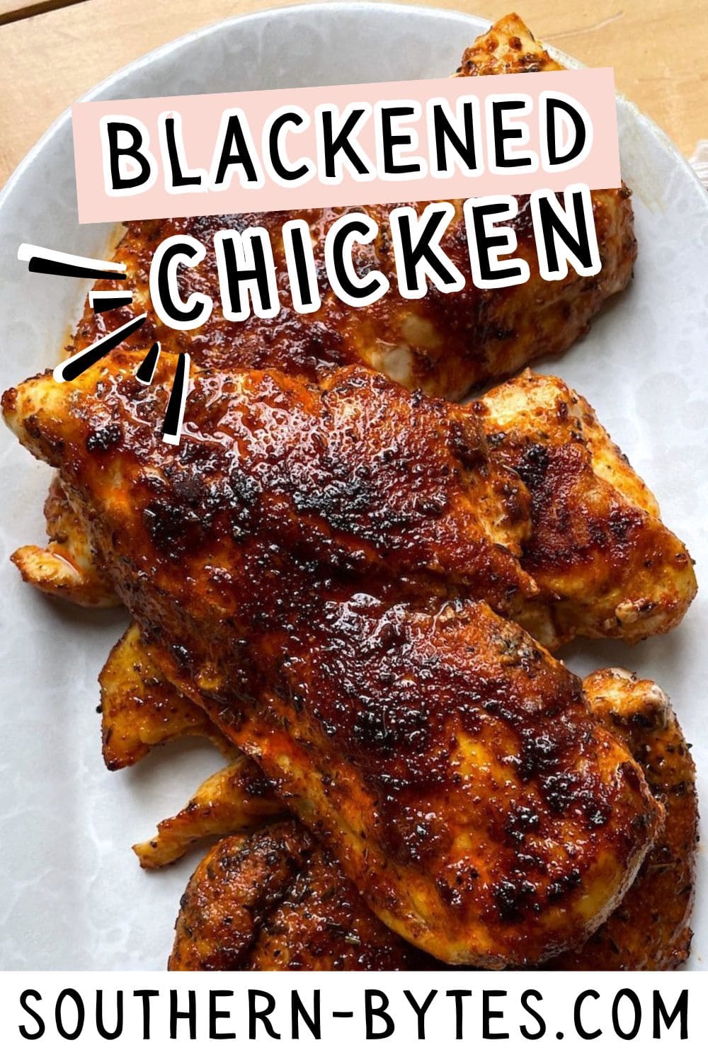 Perfectly seasoned and grilled blackened chicken breasts served on a plate.
