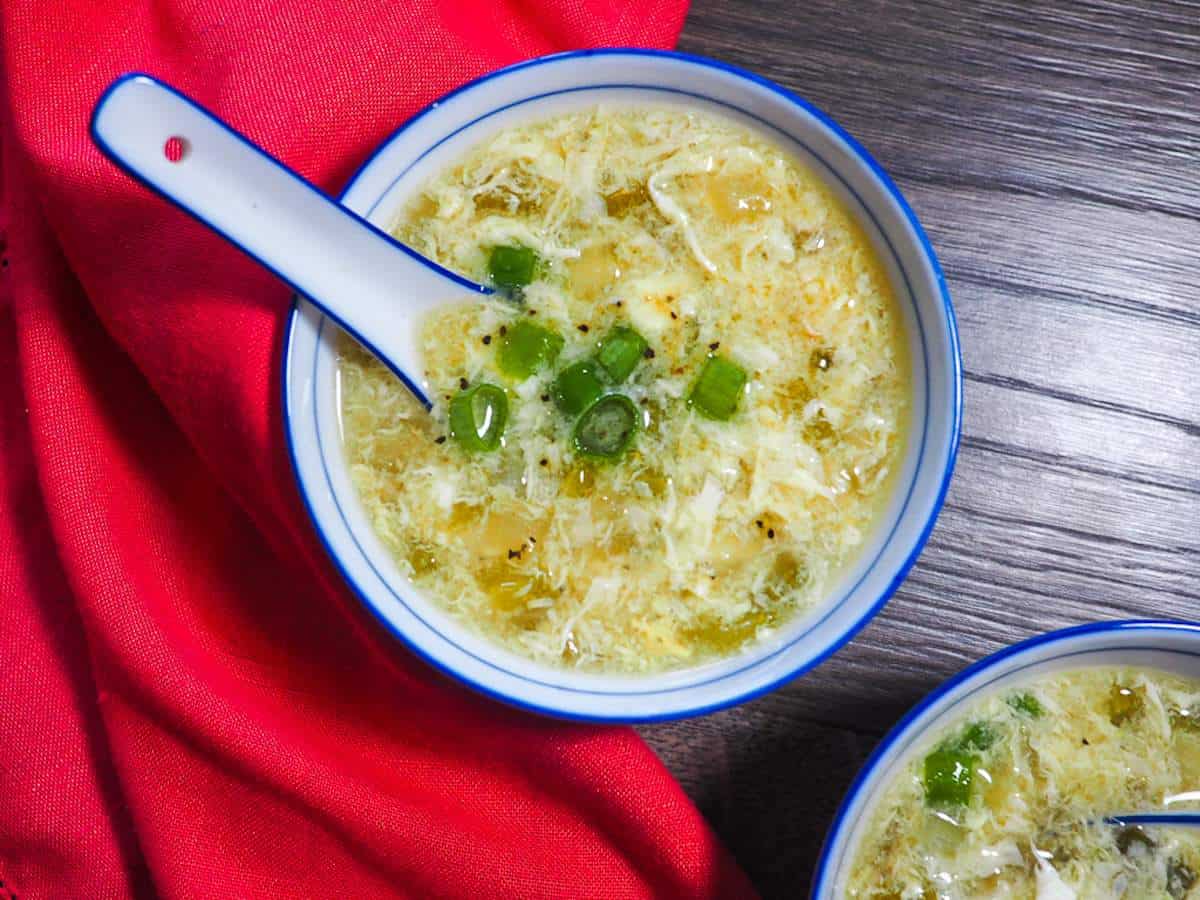 A small bowl of homemade egg drop soup topped with green onions.