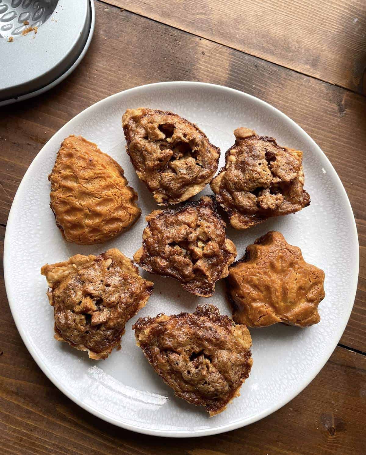 Leaf shaped pecan pie tarts on a white plate.