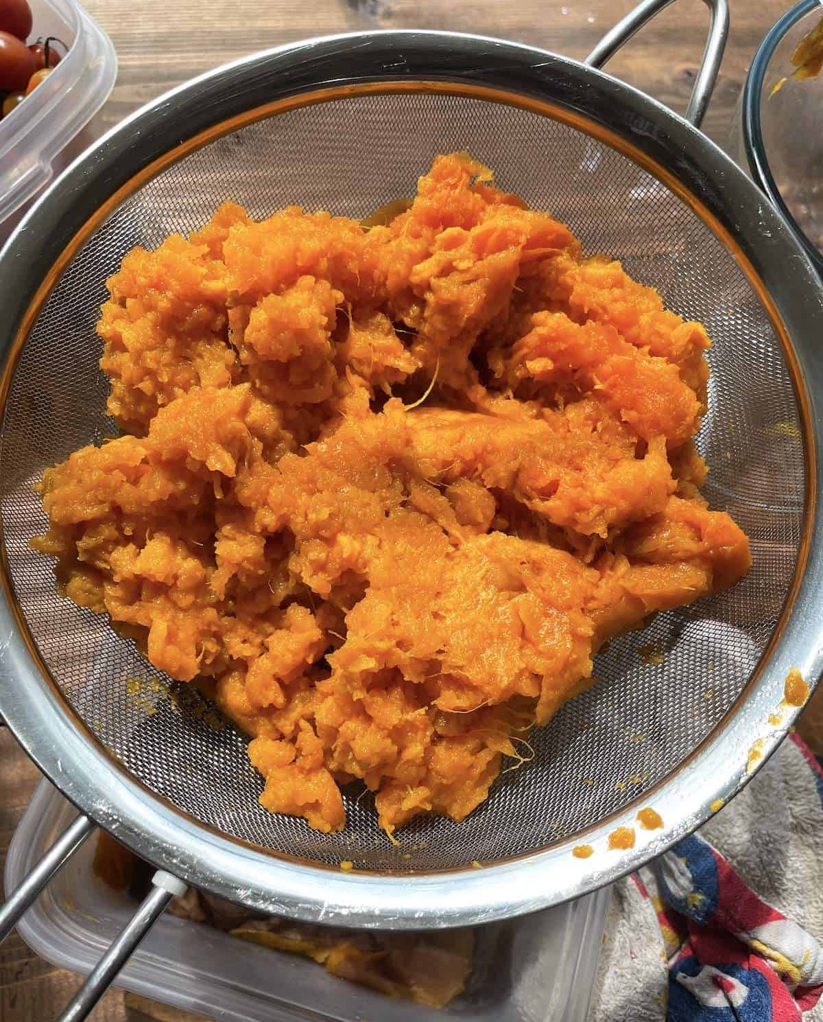 Instant Pot sweet potatoes draining in a strainer.