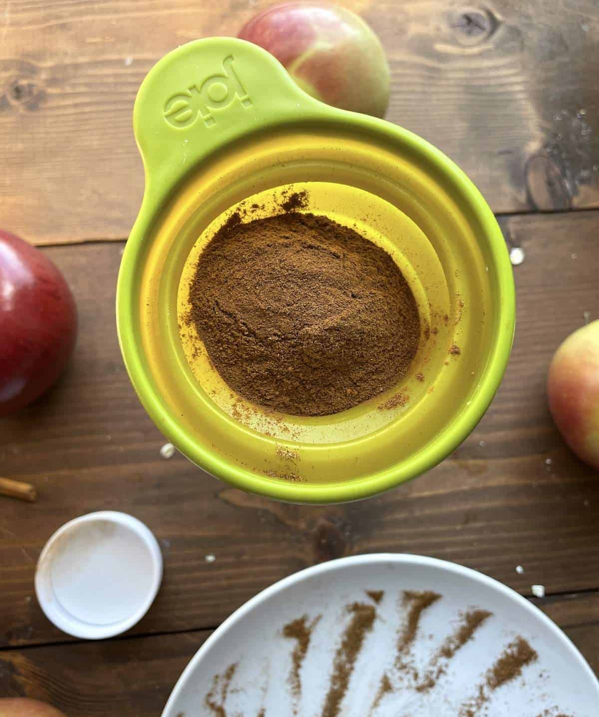 Apple pie spice mix being funneled into a jar.