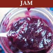 A pin image of a jar of instant pot blueberry jam being scooped out with a spoon.