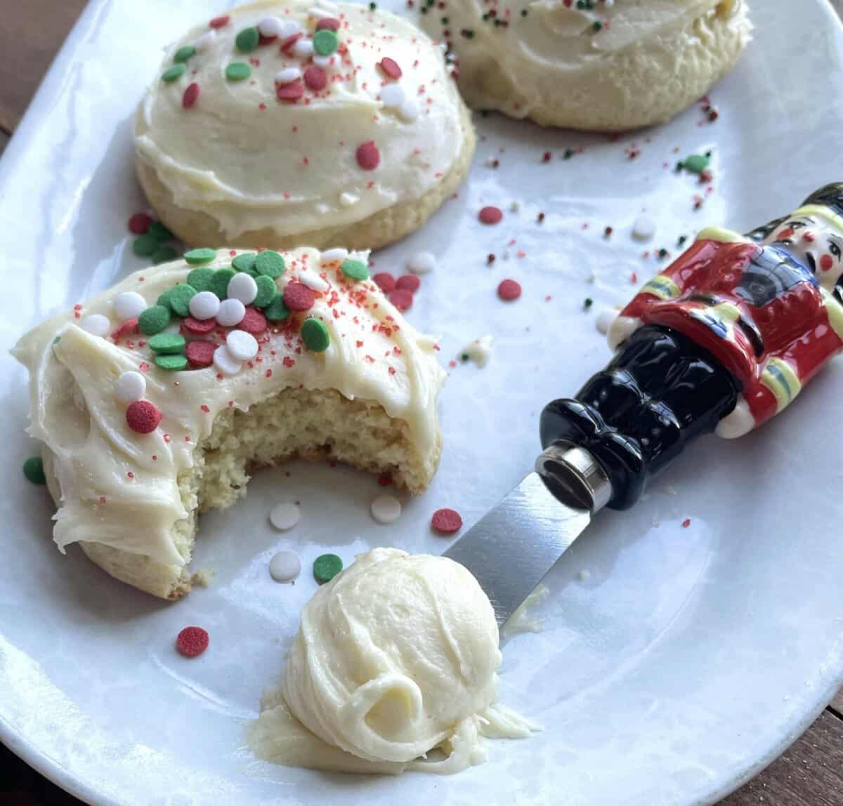 Frosted buttermilk cookies with Christmas sprinkles and nutcracker knives with extra frosting.