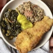 A plate of collard greens, hoppin john, and fried catfish.