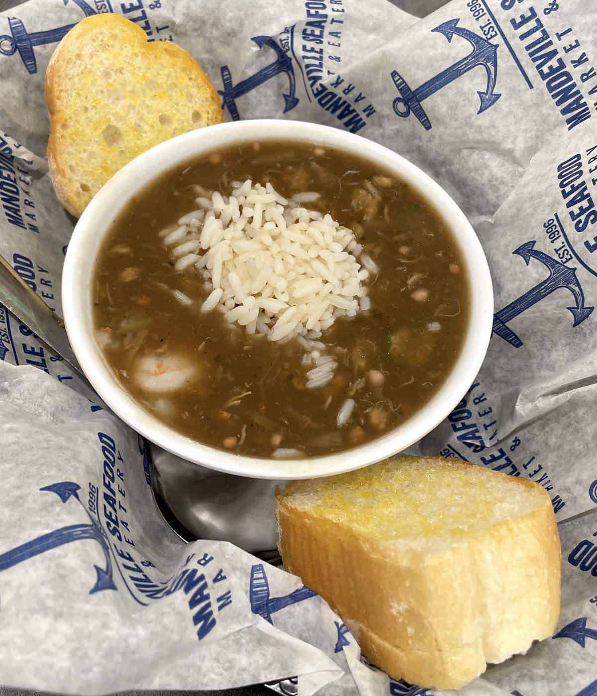 A bowl of seafood gumbo from Mandeville seafood with buttered French Bread.