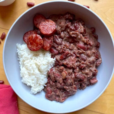A bowl of Louisiana red beans and rice with seared andouille sausage.