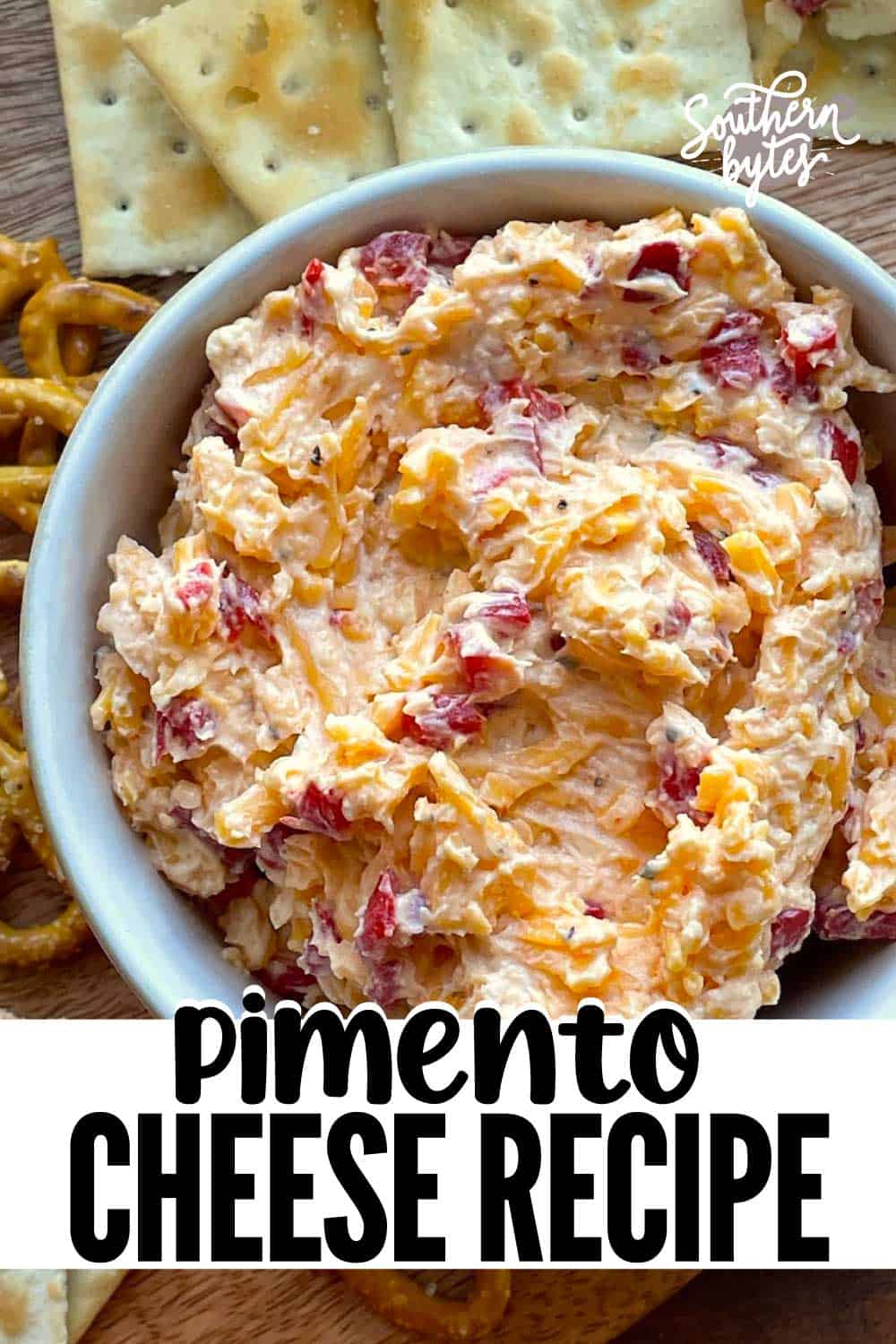 A pin image of a bowl of homemade pimento cheese surrounded by crackers.