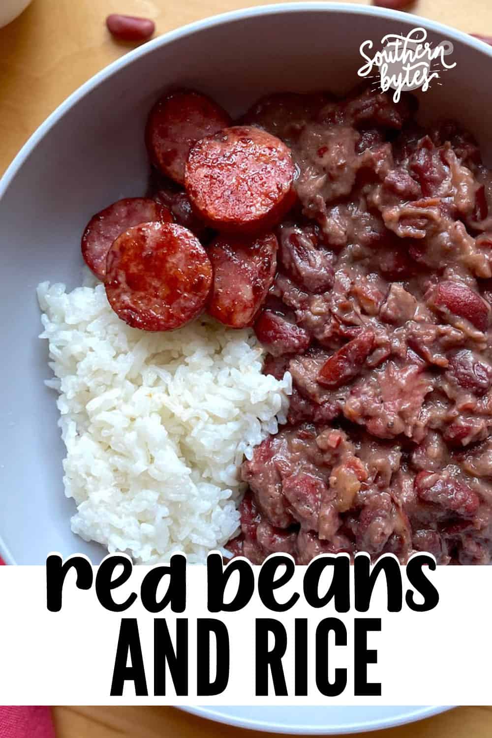 A pin image of a bowl of Louisiana red beans and rice with sliced andouille.