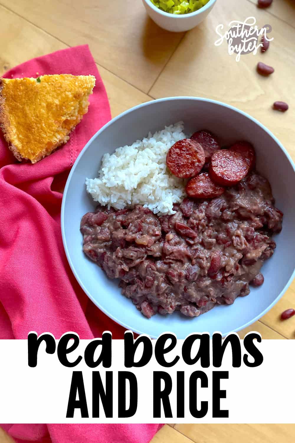 A pin image of a bowl of red beans and rice with sliced andouille and a slice of cornbread on the side.