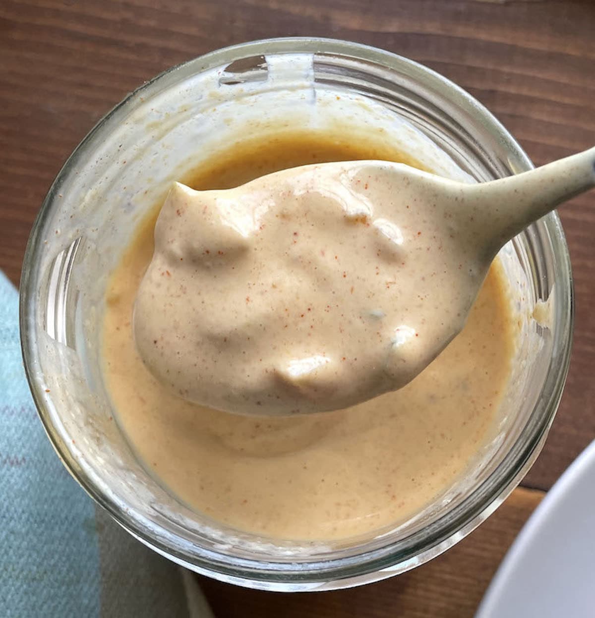 A spoon of Big Mac Sauce over a jar of the sauce drizzling back into the jar.