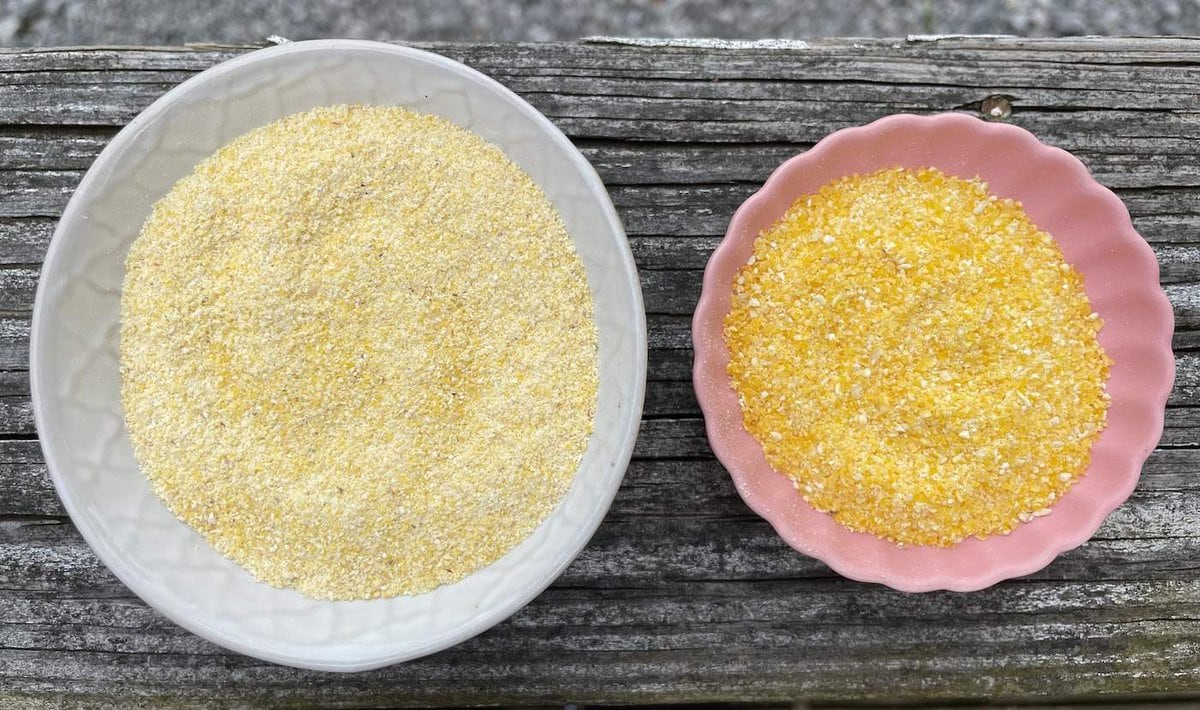 A white bowl of yellow cornmeal next to a pink bowl of yellow grits.
