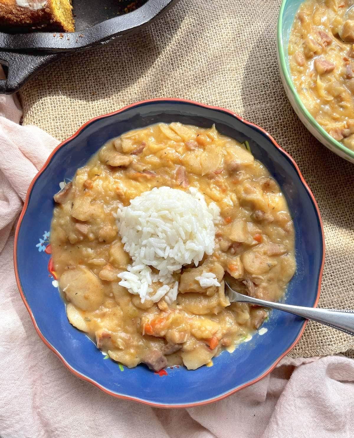 A blue bowl of creamy Southern style butter beans with a scoop of rice on top.