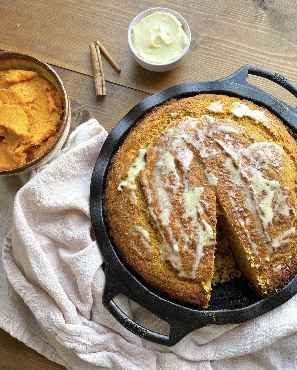 A bowl of sweet potato cornbread with honey butter spread on top.