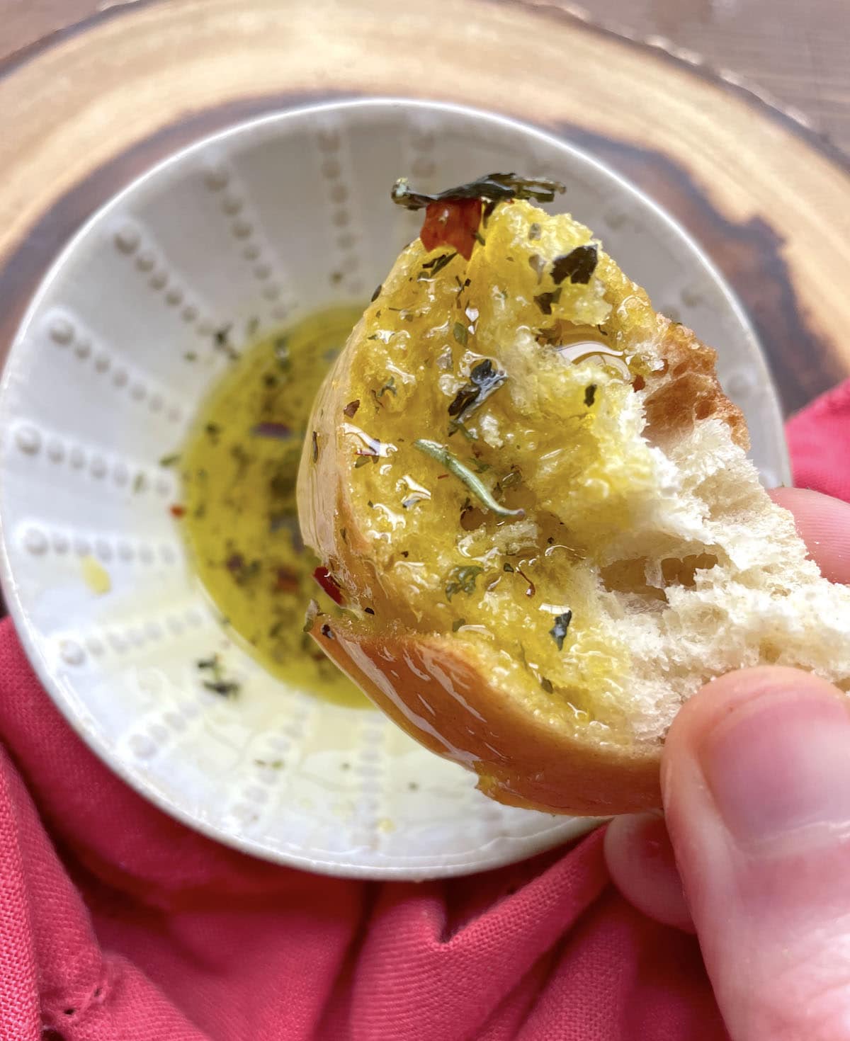 A piece of bread dunked in oil with Italian seasoning in it.