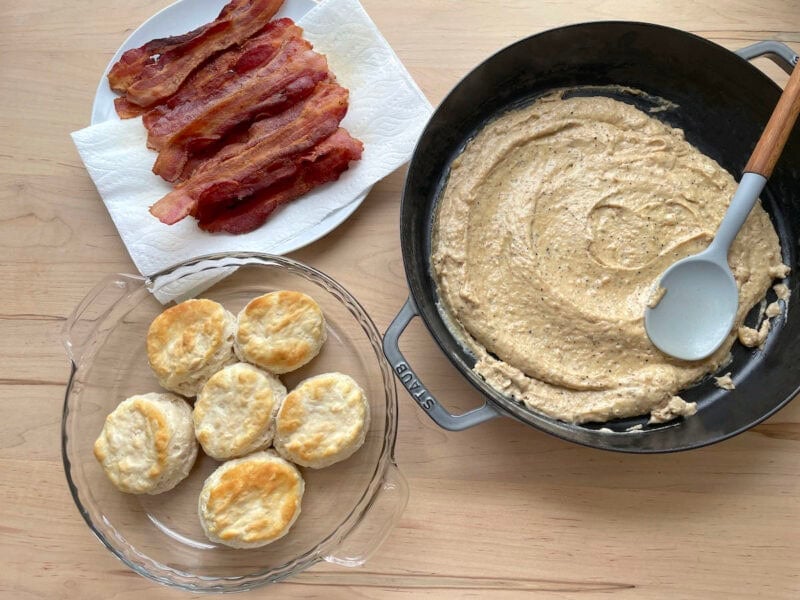 Biscuits, gravy, and bacon laid out to make biscuits with bacon gravy.
