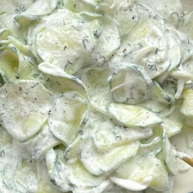 Thinly sliced cucumbers covered in a creamy dressing with fresh dill.