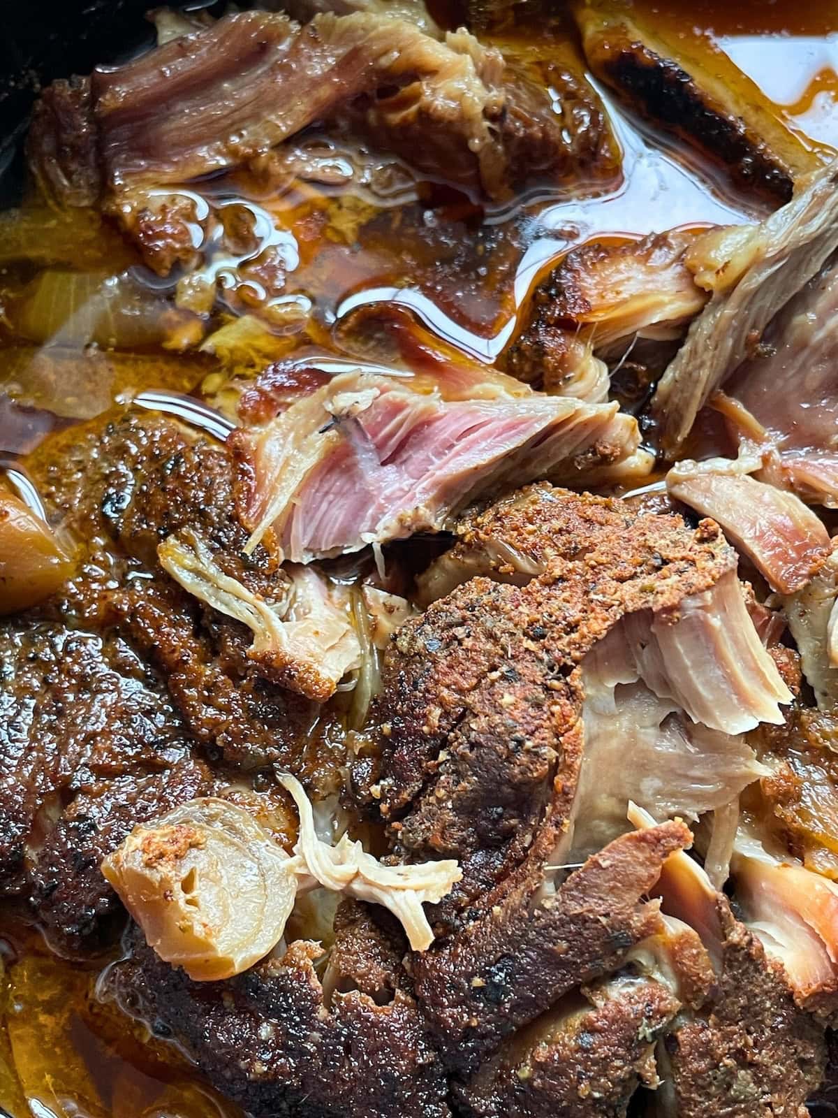 Close-up view of tender braised pork with glistening sauce and browned, crispy edges.