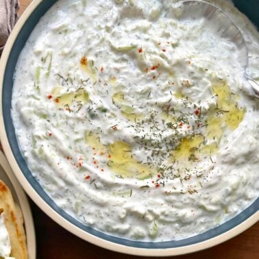 Close-up of homemade tzatziki sauce in a bowl, garnished with dill and spices.