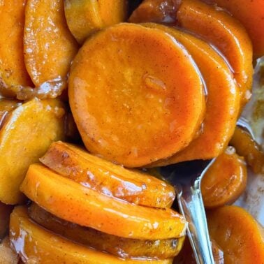 Close-up image of glazed sweet potato slices, glistening with a caramelized coating.