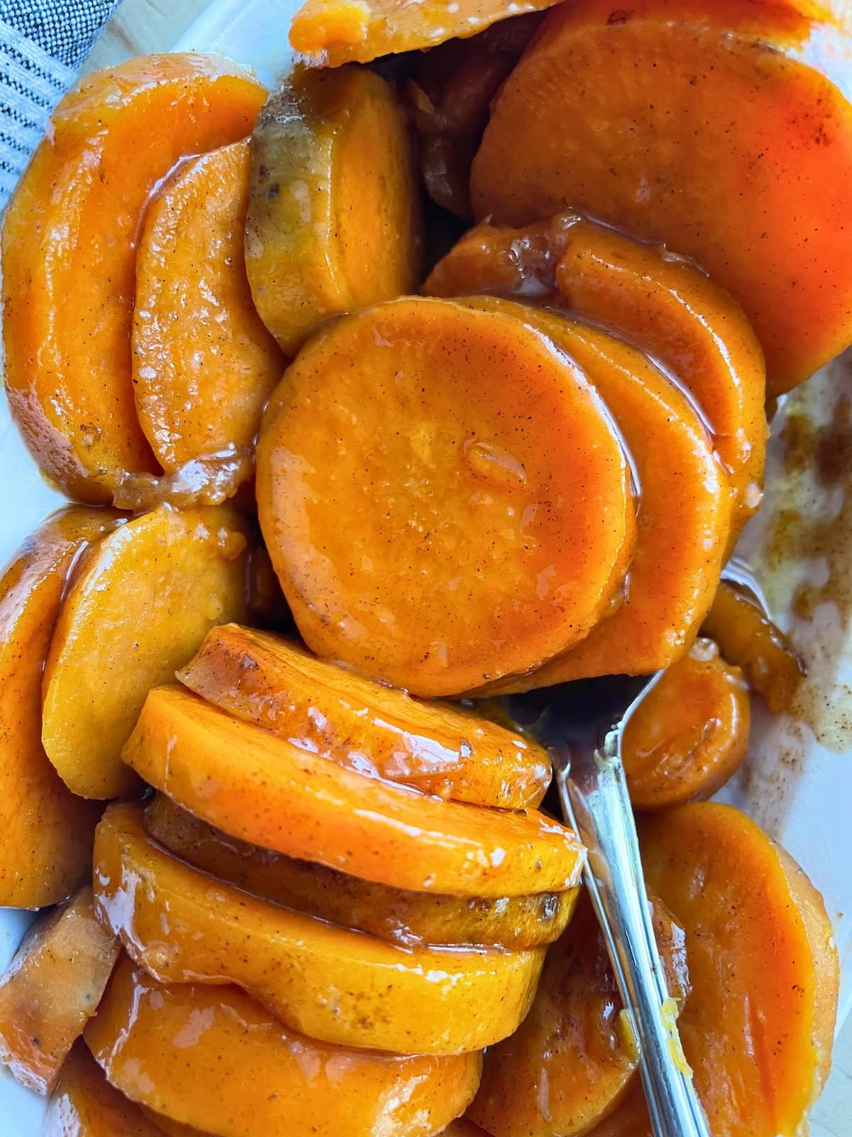 A close-up view of glazed and candied sweet potato slices on a plate.