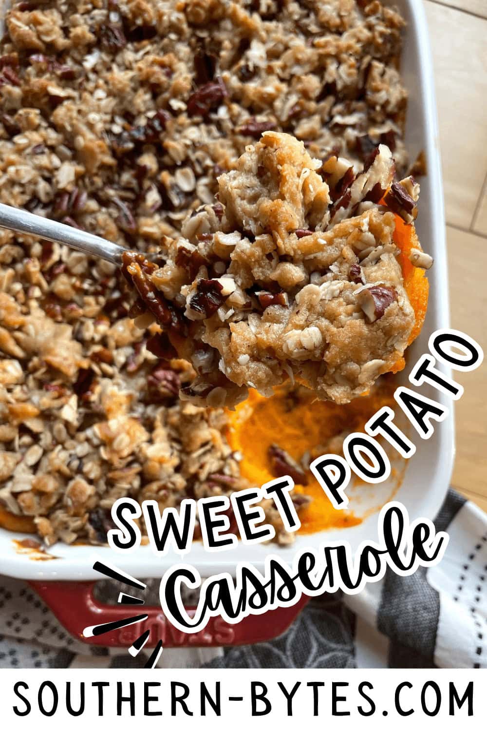 A pin image of a close-up of a sweet potato casserole with a crunchy pecan topping being served.