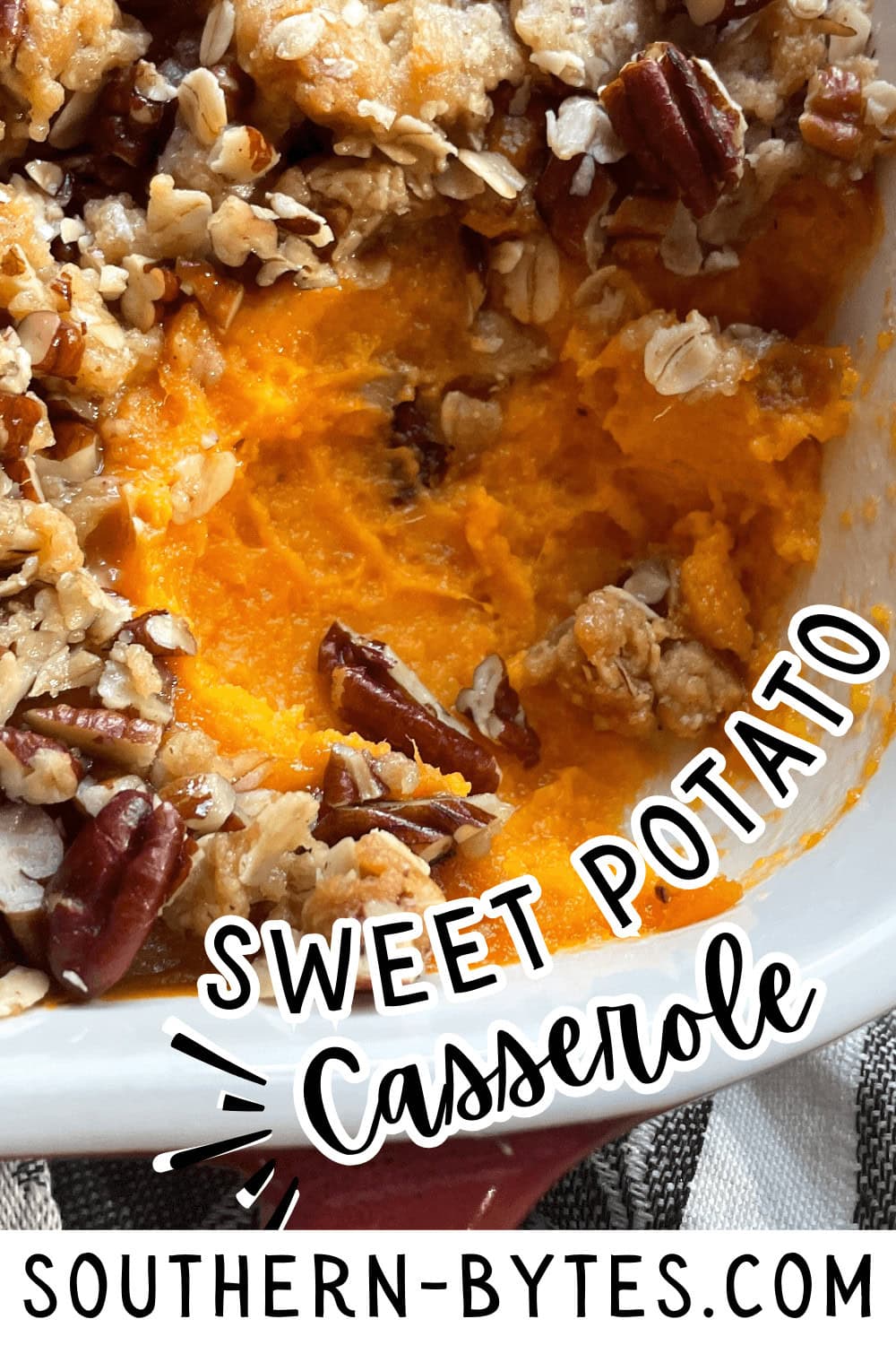 A pin image of a close-up of a sweet potato casserole with pecans and a crunchy oat topping served in a white baking dish.