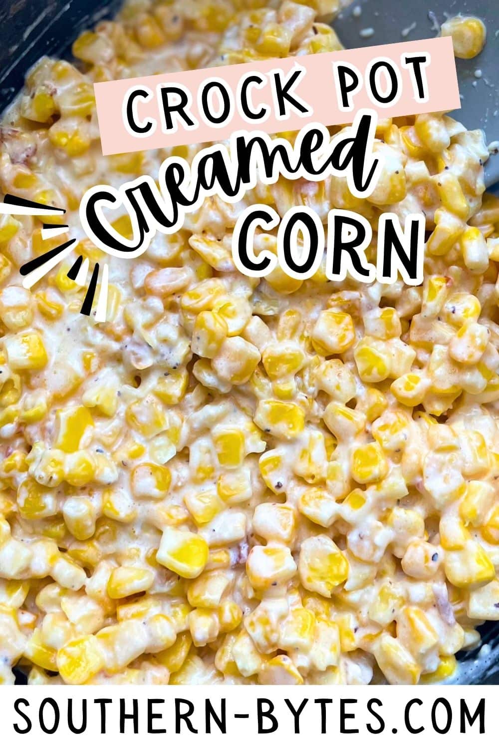 A pin image of a close-up of creamy corn cooked in a crock pot.