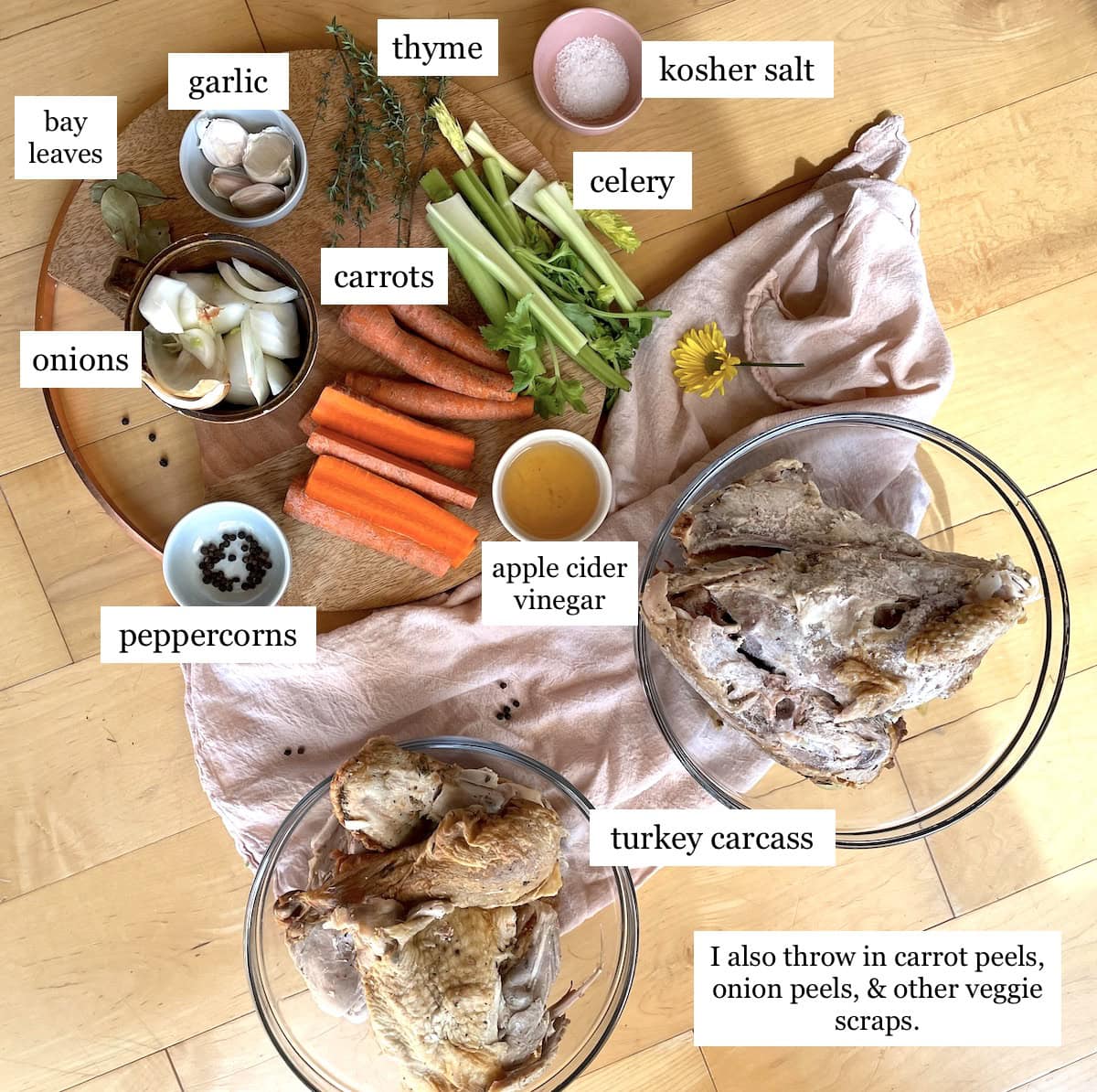 A turkey carcass, vegetables, and seasonings laid out on a wooden surface, labeled for making homemade turkey broth in an instant pot.