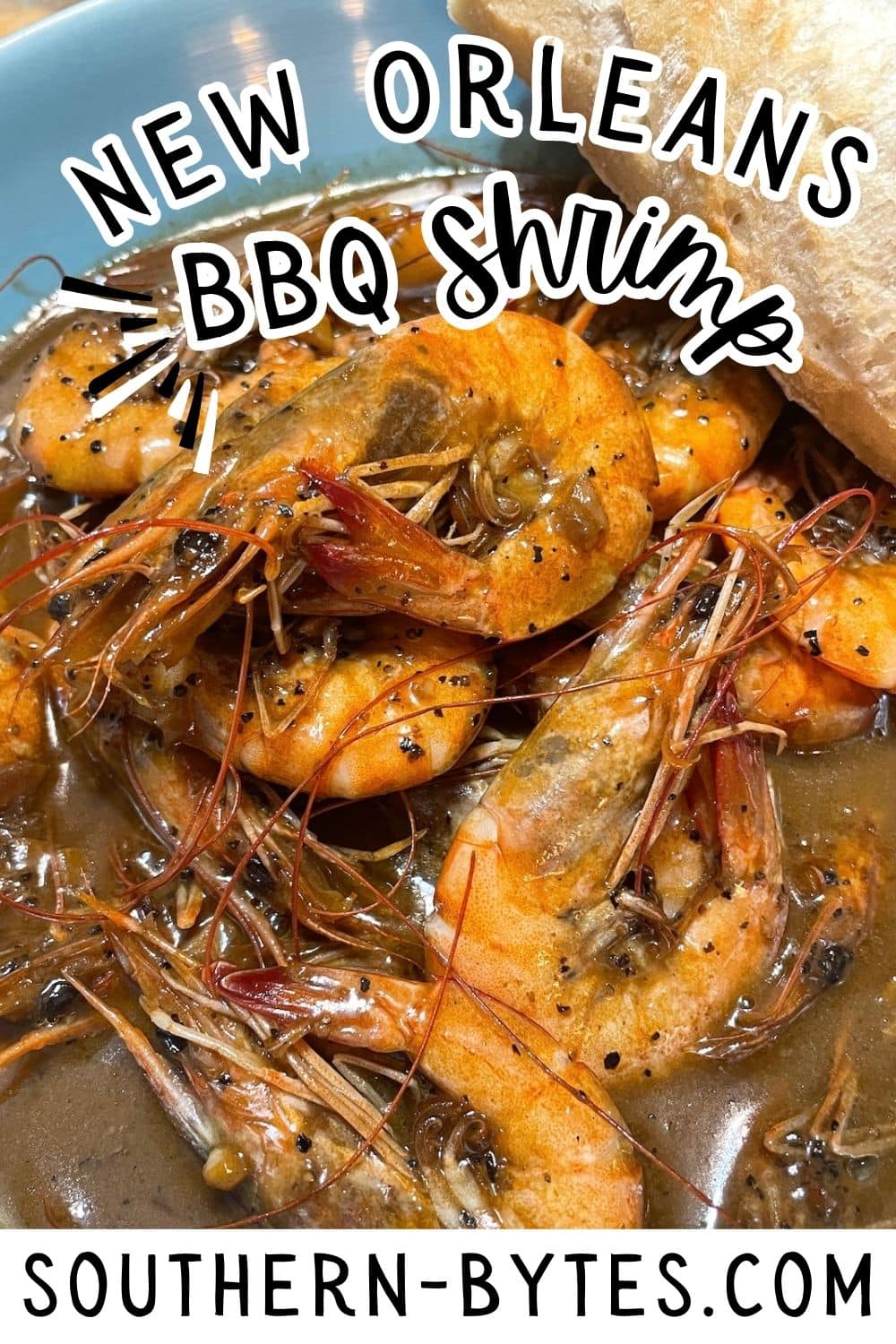 A pin image of a bowl of New Orleans style BBQ shrimp with bread and seasoning.