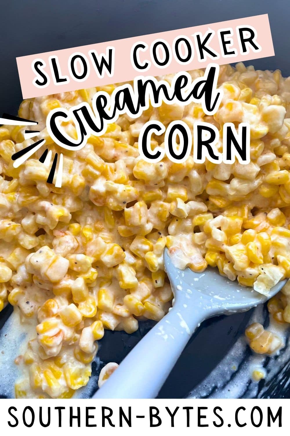 A pin image of a close-up image of slow cooker creamed corn in a crockpot with a gray spoon.