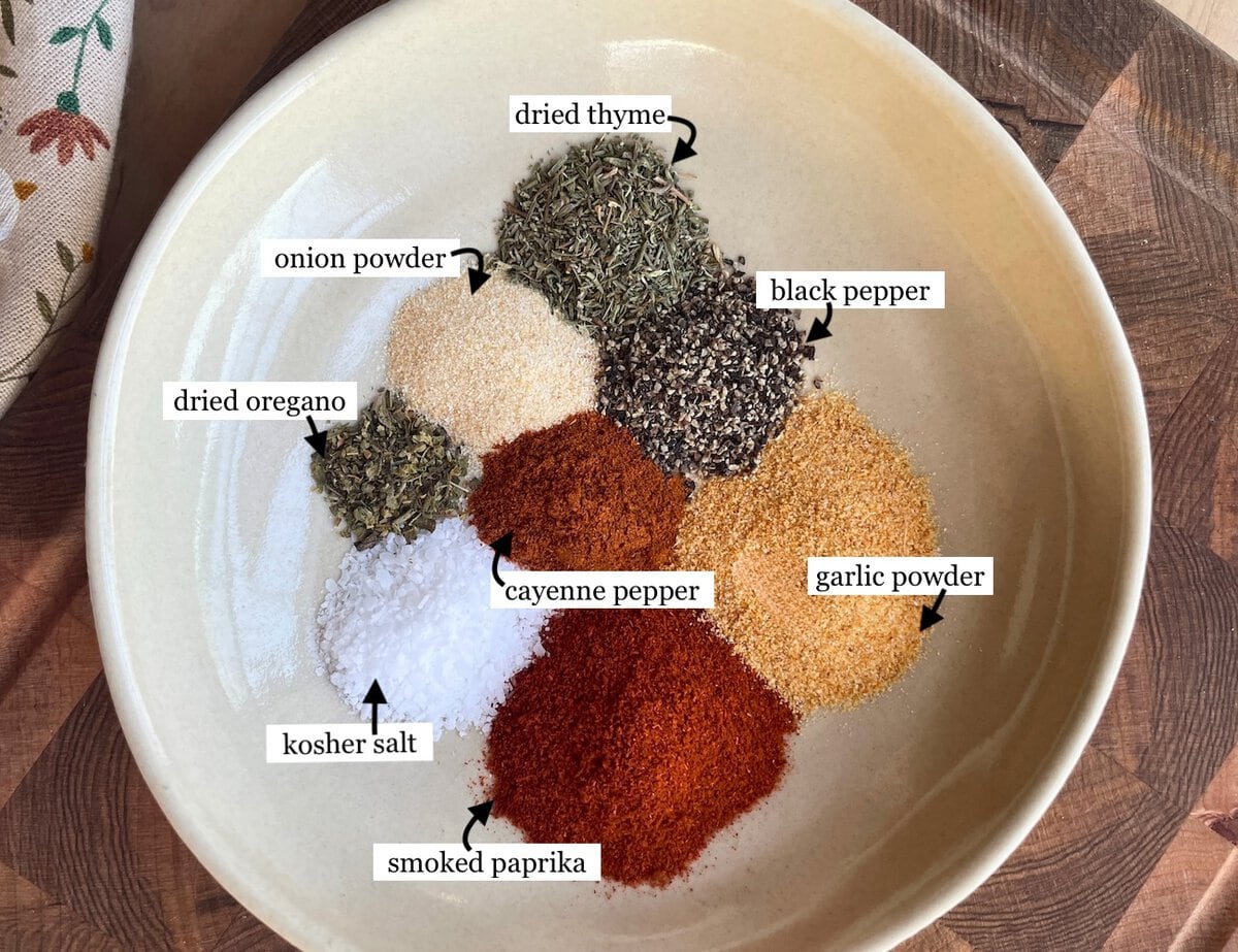 The ingredients in Cajun blackening seasoning laid out and labeled in a bowl.